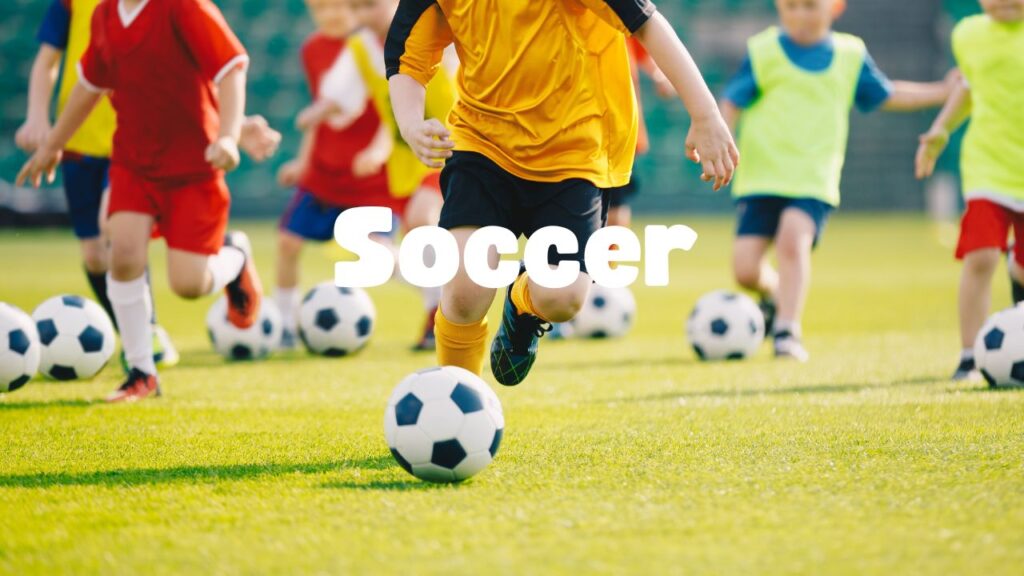 A group of young people playing soccer on the grass.